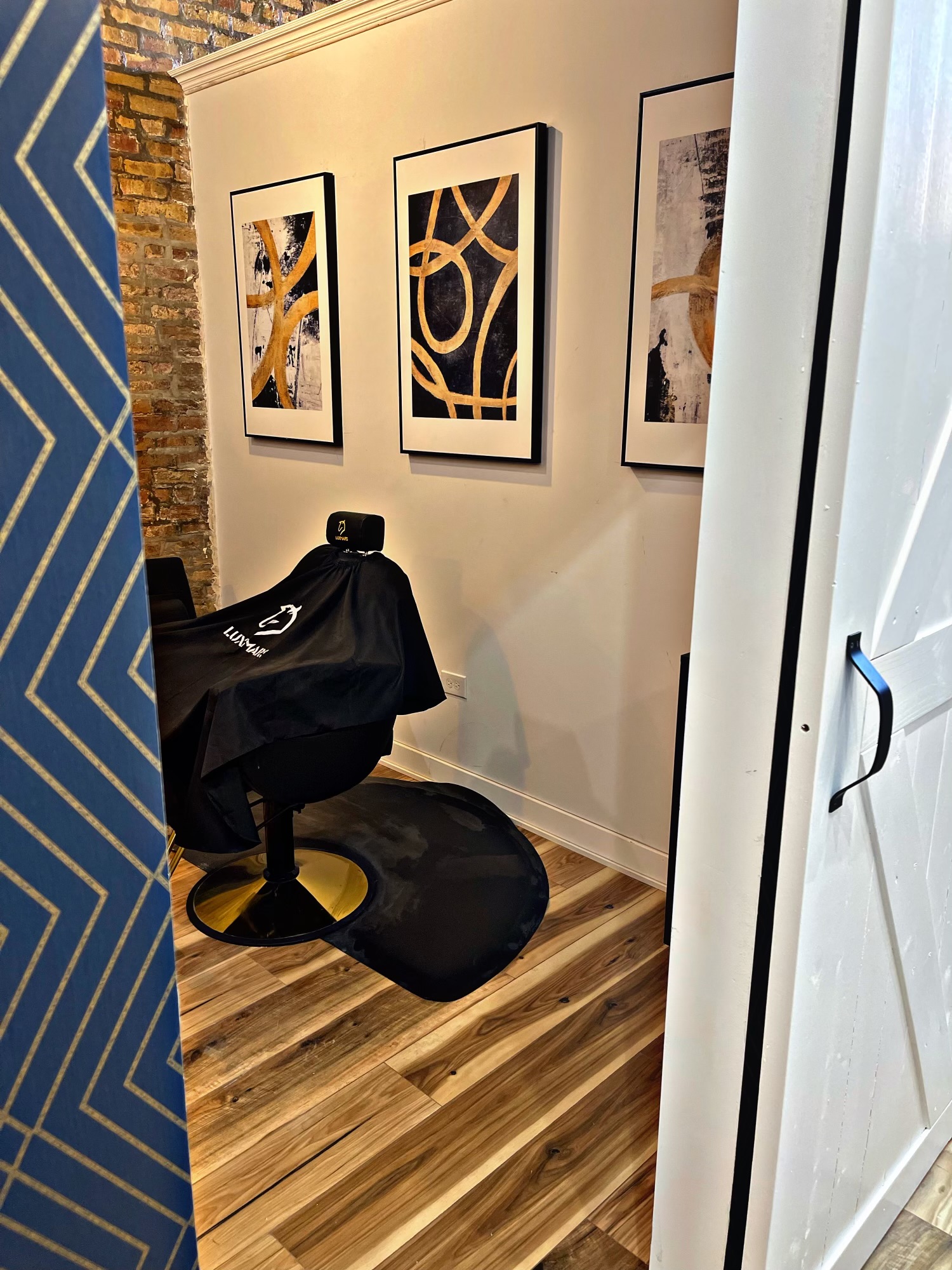 Bronzeville private styling room with black and gold chair and framed artwork