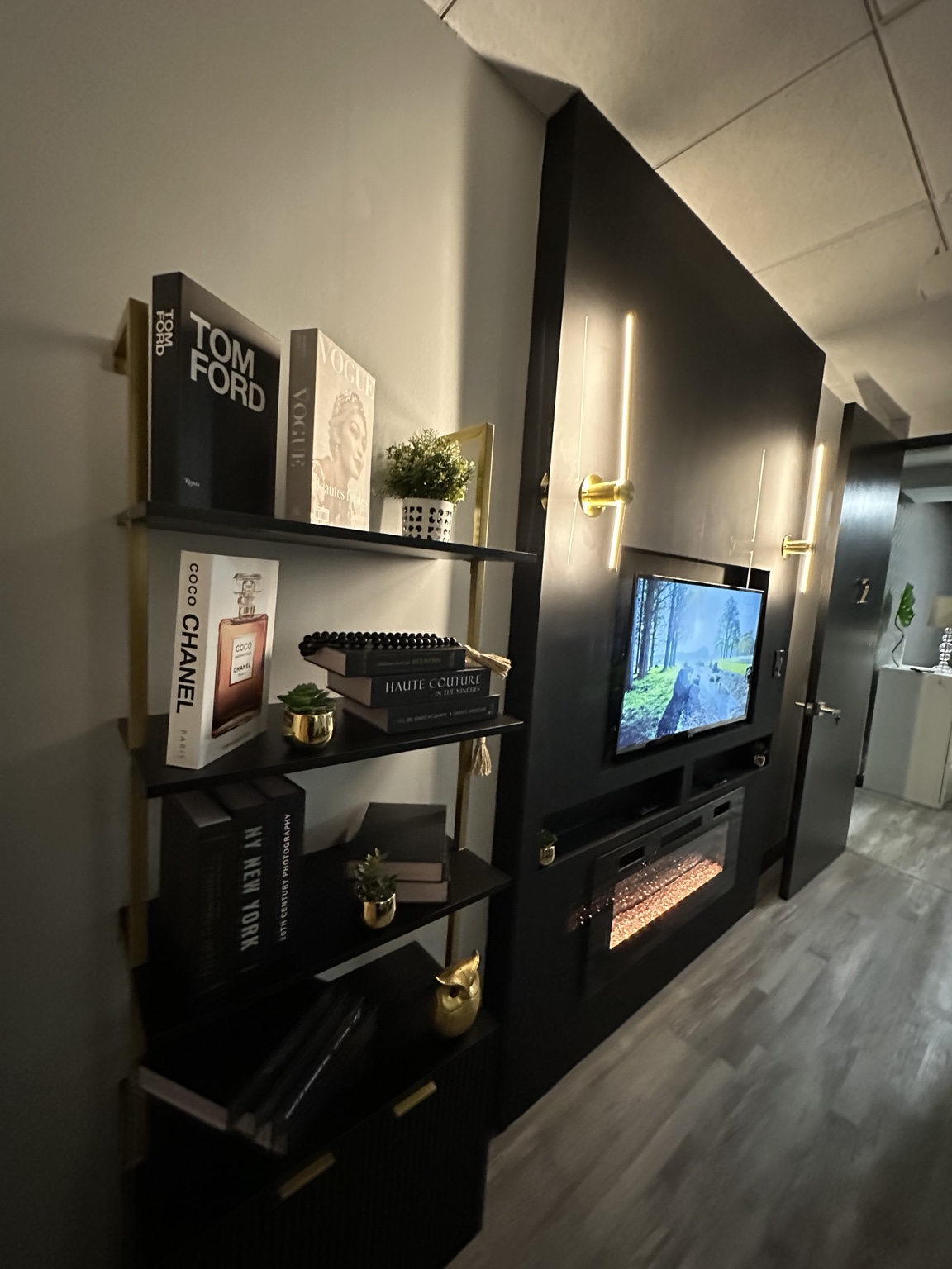Downtown Chicago suite with black and gold shelving, television, and fireplace