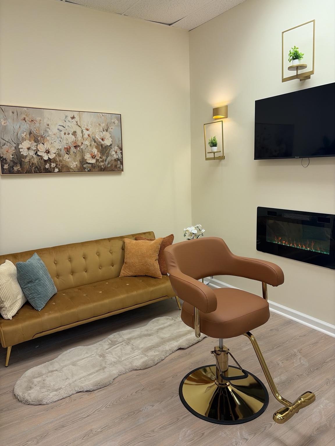 Stonecrest suite with gold sofa, styling chair, television, and fireplace