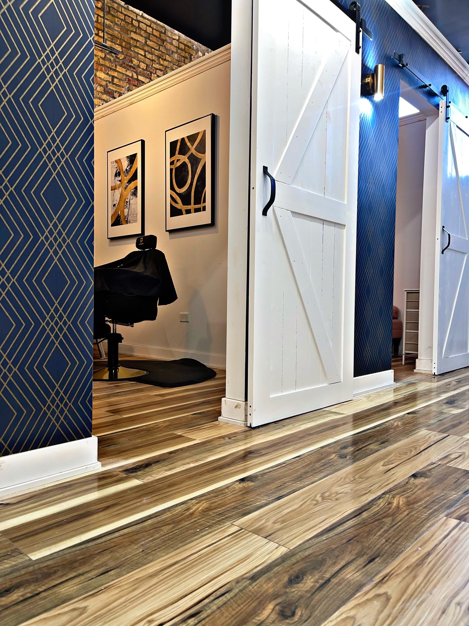 Suites with navy and gold walls, white sliding doors, exposed brick, and wood floors
